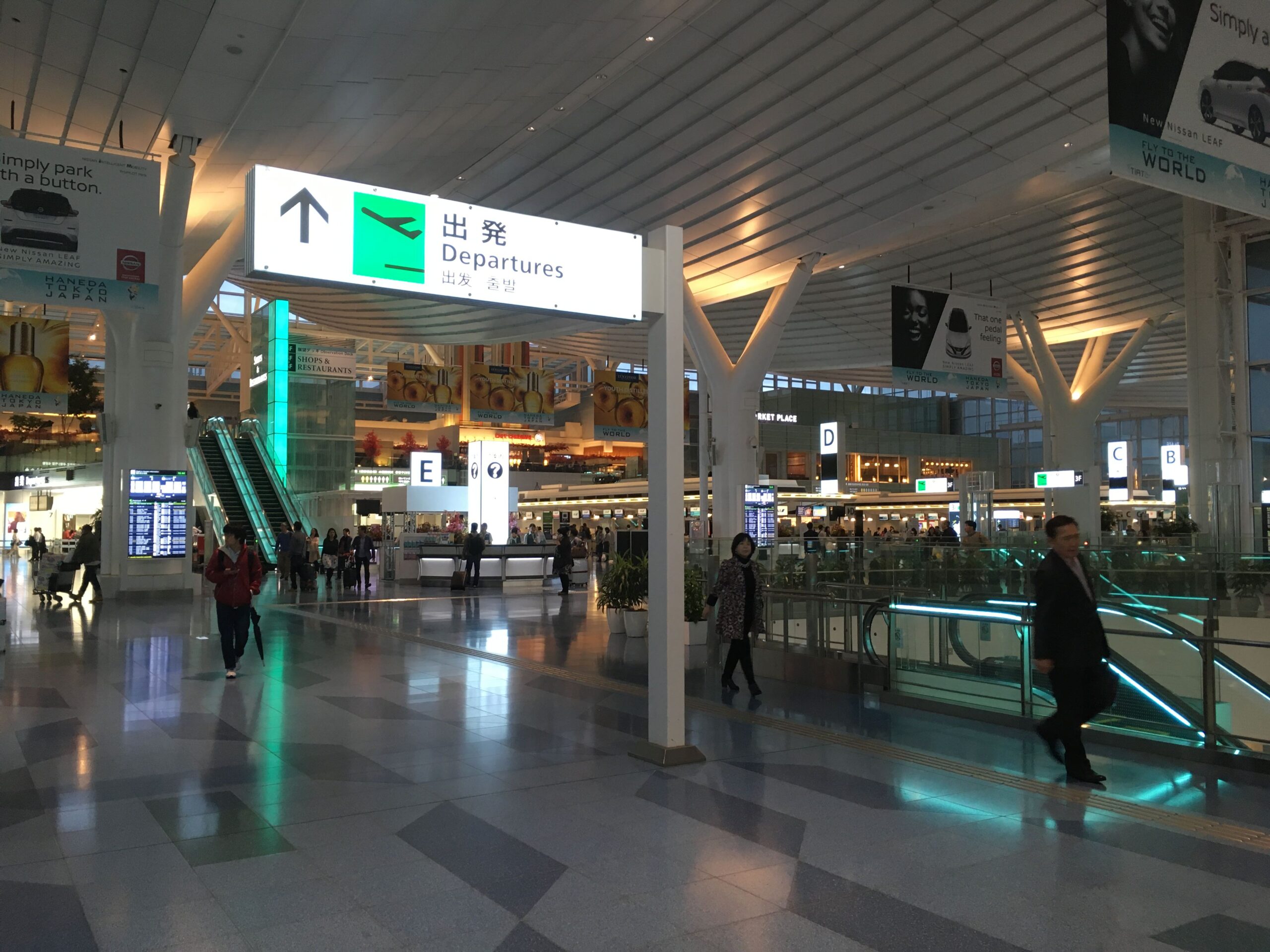 Haneda airport departure sign with escalators in the background
