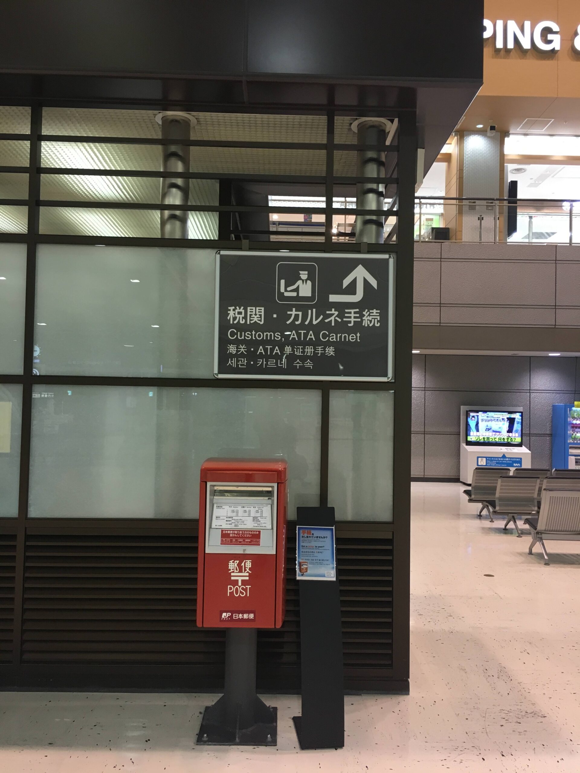 Narita Airport Terminal 1 red postbox near the customs signage.