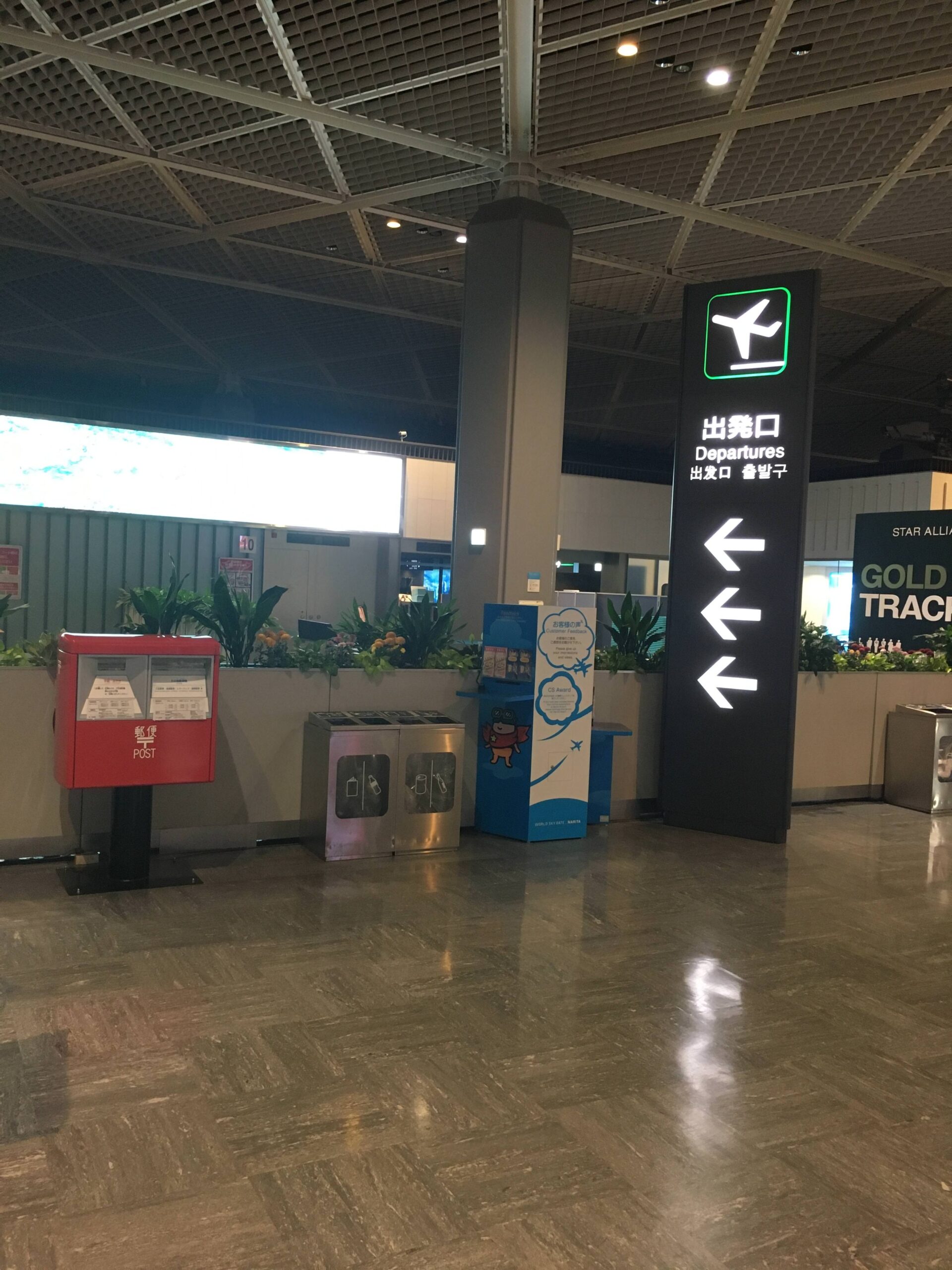 Narita Airport Terminal 2 red postbox near the departures signage.